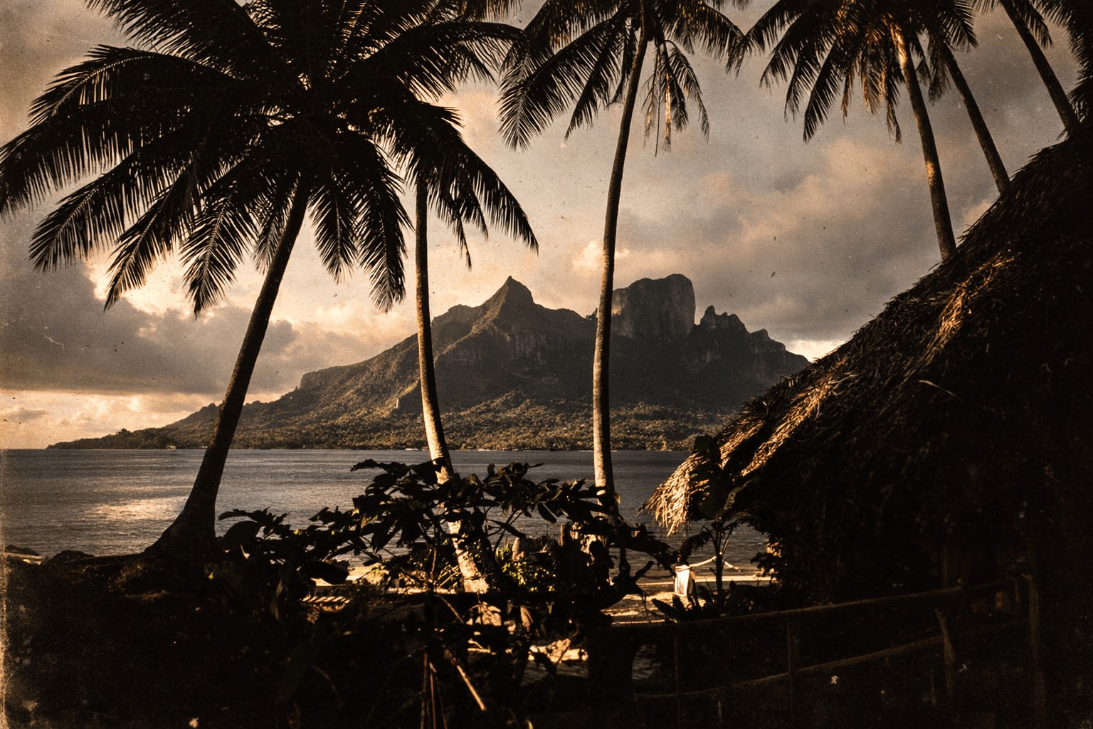 Vue aérienne du Bloody Mary's Hotel et de ses bungalows longeant le lagon turquoise de Bora Bora, encadré par le Mont Otemanu.